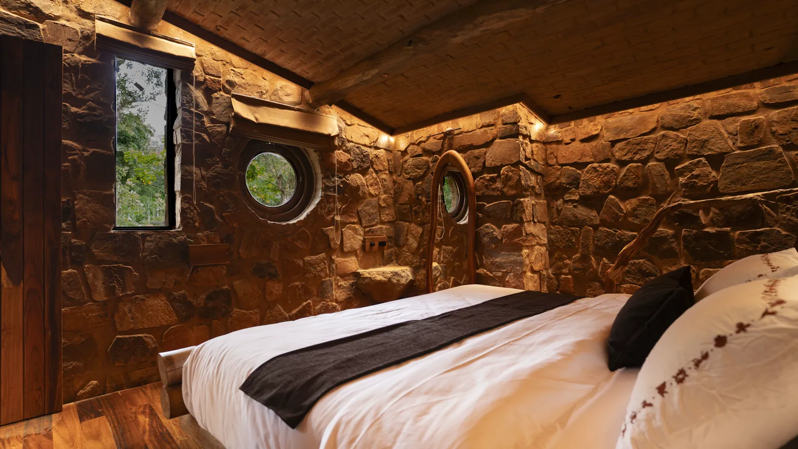 The Burrow — the bedroom, stone walls and porthole windows